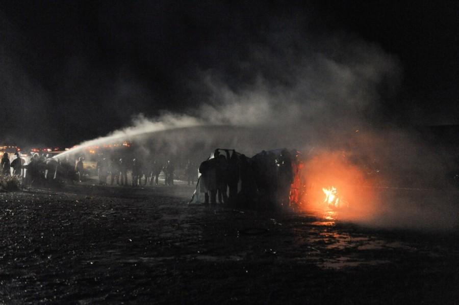 Police use a water cannon to put out a fire started by protesters during a protest against plans to pass the Dakota Access pipeline near the Standing Rock Indian Reservation, near Cannon Ball, North Dakota, U.S. November 20, 2016. North Dakota,North Dakota pipeline protest,Dakota Access oil pipeline project,Native American tribe,Native American
