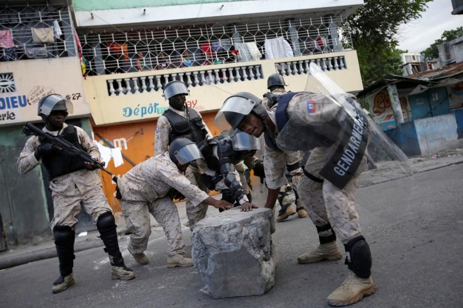 Haitian National Police officers clear a barricade set up by supporters of Fanmi Lavalas political party during a demonstration in the streets of Port-au-Prince, Haiti. Tensions mount as Haiti,Haiti,Haiti relection,Haiti waits for election results,Haiti for election resultselection results,election results,Caribbean country