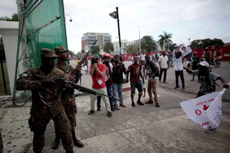 Members of the General Security Unit of the National Palace (USGPN) try to disperse supporters of Fanmi Lavalas political party as they march next to the National Palace of Port-au-Prince, Haiti. Election tensions spilled onto Haiti's streets on Monday with shots fired outside the presidential palace as various candidates claimed victory in a re-run vote in the impoverished Caribbean country. Tensions mount as Haiti,Haiti,Haiti relection,Haiti waits for election results,Haiti for election resultselection results,election results,Caribbean country