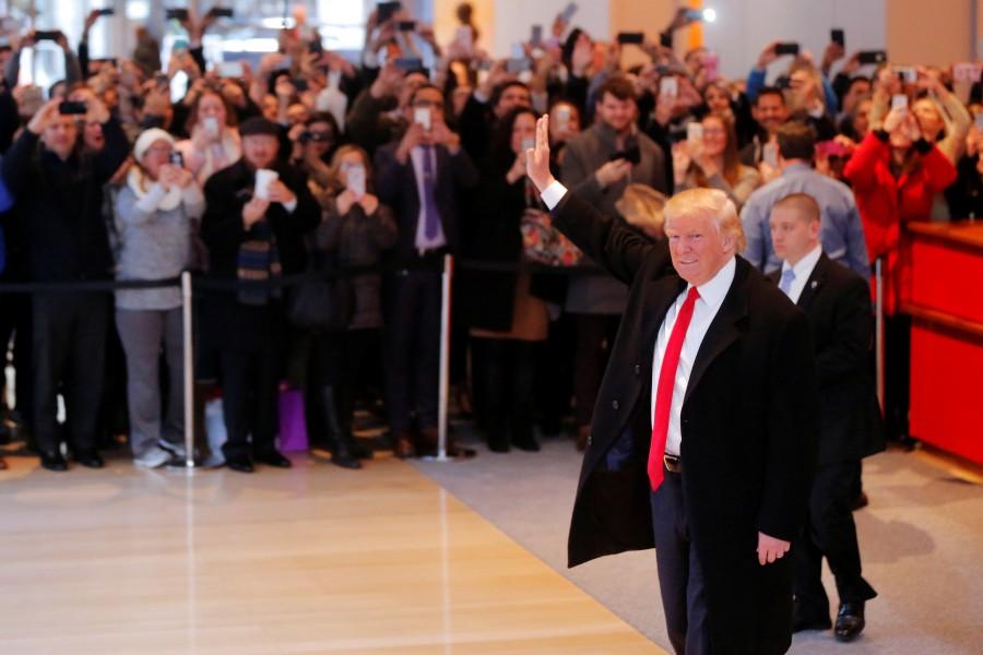 President-elect Donald Trump reacts to a crowd gathered in the lobby of the New York Times building. Trump, who has never previously held public office, was quick to bristle at unflattering news coverage during the campaign, even as he remained accessible to certain reporters, including several from the Times. Donald Trump,President-elect Donald Trump,Donald Trump meets New York Journalists,Donald Trump meets New York Journalists and executives,New York Journalists,New York Journalists and executives