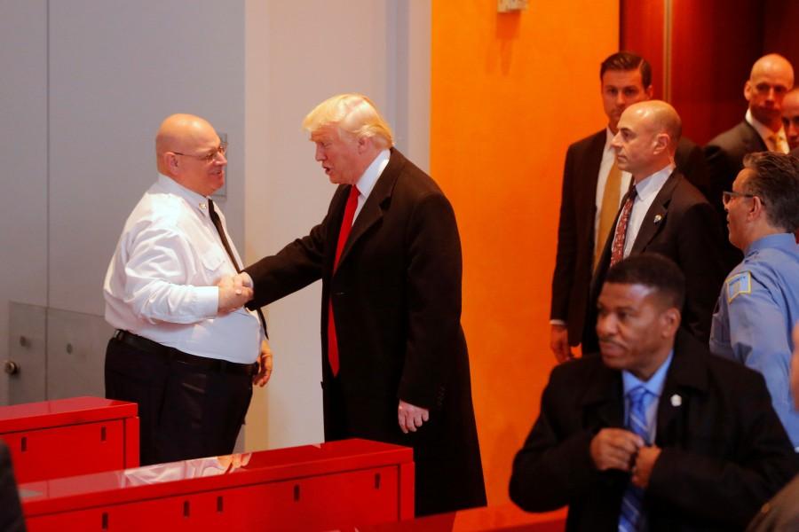 President-elect Donald Trump greets a security guard as he departs the lobby of the New York Times building. Donald Trump,President-elect Donald Trump,Donald Trump meets New York Journalists,Donald Trump meets New York Journalists and executives,New York Journalists,New York Journalists and executives