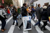 A man carries a television across 6th Avenue during Black Friday sales in Manhattan, New York.