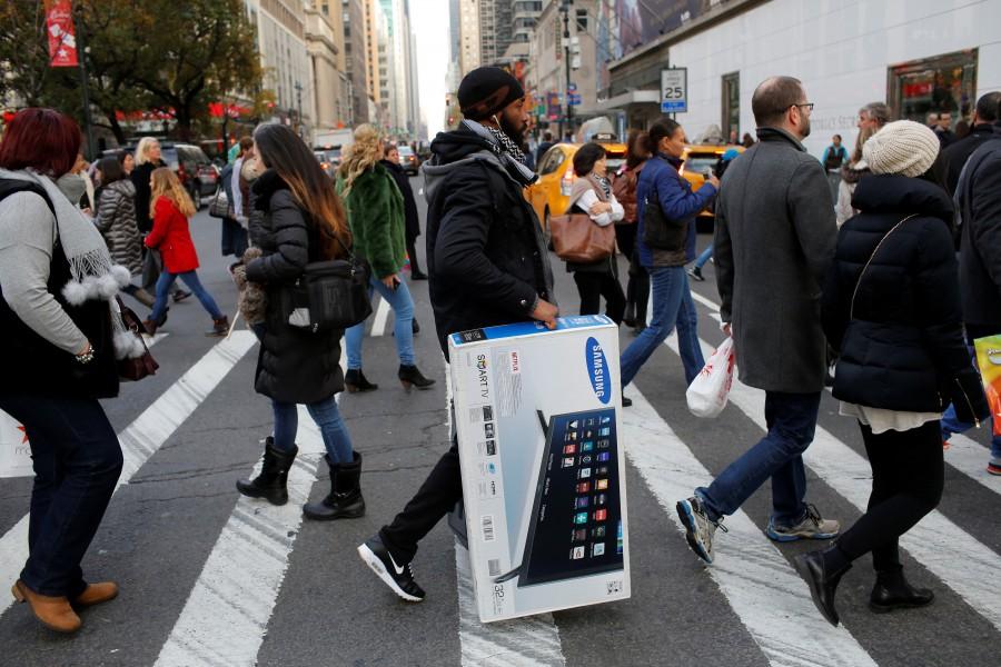 A man carries a television across 6th Avenue during Black Friday sales in Manhattan, New York. Thanksgiving,Thanksgiving bargain hunt,Black Friday frenzy,Black Friday frenzy pics,Black Friday frenzy images,Black Friday frenzy photos,Black Friday frenzy stills,Black Friday frenzy pictures