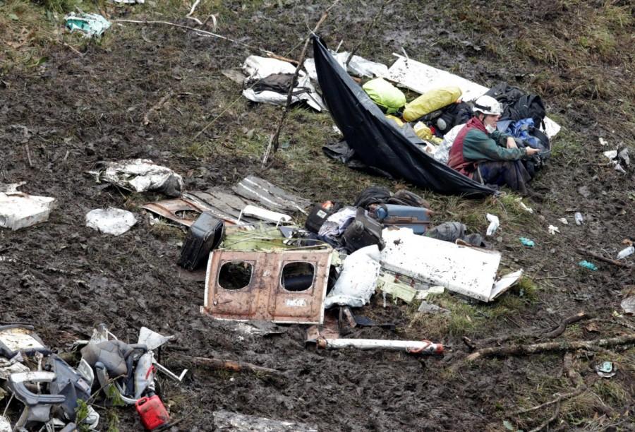 A rescue worker sits near the wreckage of a plane that crashed into the Colombian jungle with Brazilian soccer team Chapecoense onboard near Medellin, Colombia, November 29, 2016. Brazilian soccer team crashes,Plane crash,Brazilian soccer team,Chapecoense,Colombian mountains