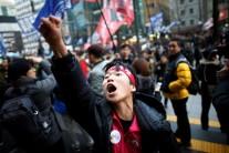 A member of Korean Confederation of Trade Unions shouts in front of Samsung's main building as they march during a general strike calling for South Korean President Park Geun-hye to step down, in central Seoul, South Korea November 30, 2016.