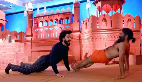 Photos of Bollywood actor Ranveer Singh performs Yoga with Baba Ramdev in New Delhi.