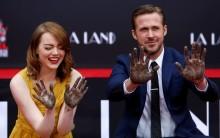 Photos of Emma Stone and Ryan Gosling place their hands in cement at the TCL Chinese theatre in Hollywood.
