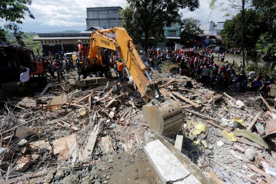 Rescue workers use heavy equipment to search for victims in a collapsed building following an earthquake in Lueng Putu, Pidie Jaya in the northern province of Aceh, Indonesia. Quake Strikes Indonesia,Strong Quake,Strong Quake Strikes Indonesia,strong earthquake,Sumatra,Indonesia,Indonesia earthquake,Indonesia earthquake pics,Indonesia earthquake images,Indonesia earthquake photos,Indonesia earthquake stills
