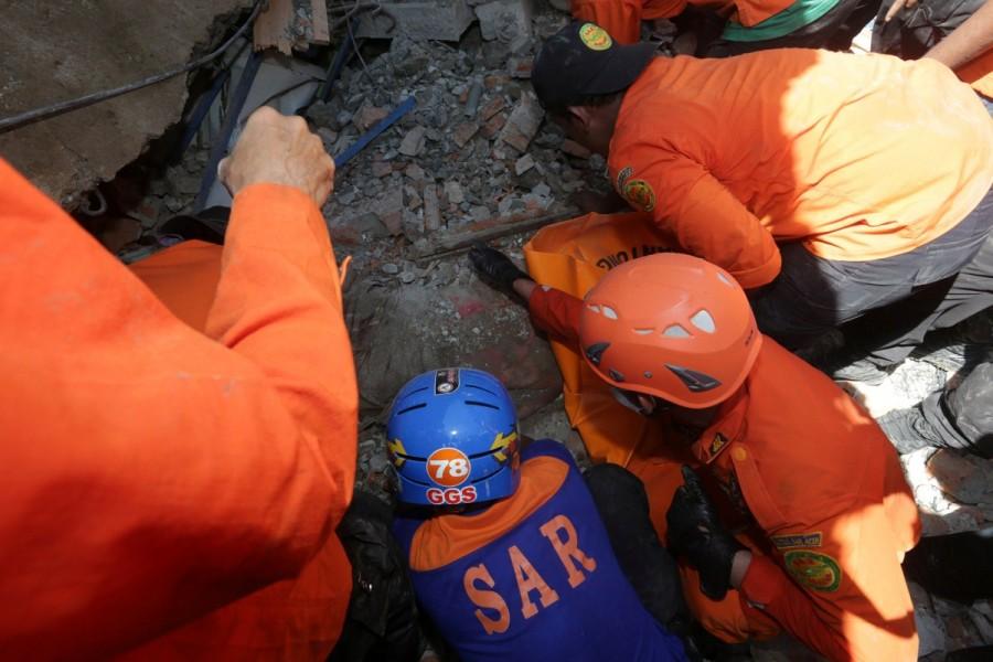 Rescue workers try to remove a victim from a collapsed building following an earthquake in Lueng Putu, Pidie Jaya in the northern province of Aceh, Indonesia. Quake Strikes Indonesia,Strong Quake,Strong Quake Strikes Indonesia,strong earthquake,Sumatra,Indonesia,Indonesia earthquake,Indonesia earthquake pics,Indonesia earthquake images,Indonesia earthquake photos,Indonesia earthquake stills