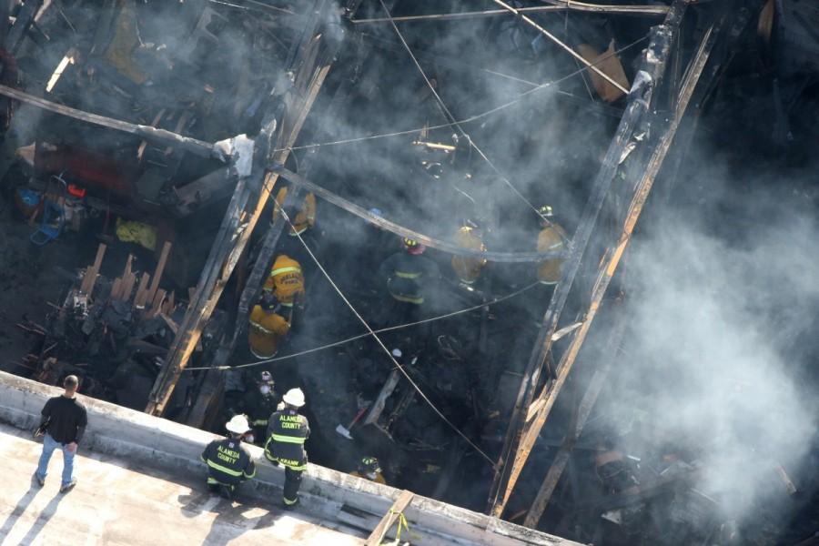 Firefighters work inside the burned warehouse following the fatal fire in the Fruitvale district of Oakland, California. Deadly California warehouse fire,California warehouse fire,California warehouse fire pics,California warehouse fire images,California warehouse fire photos,California warehouse fire stills,California warehouse fire pictures