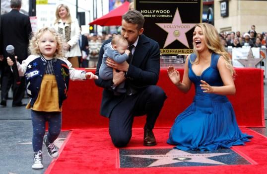 Actor Ryan Reynolds kisses his daughter while posing by his star with his wife Blake Lively and their daughter James on the Hollywood Walk of Fame in Hollywood, California U.S., December 15, 2016.