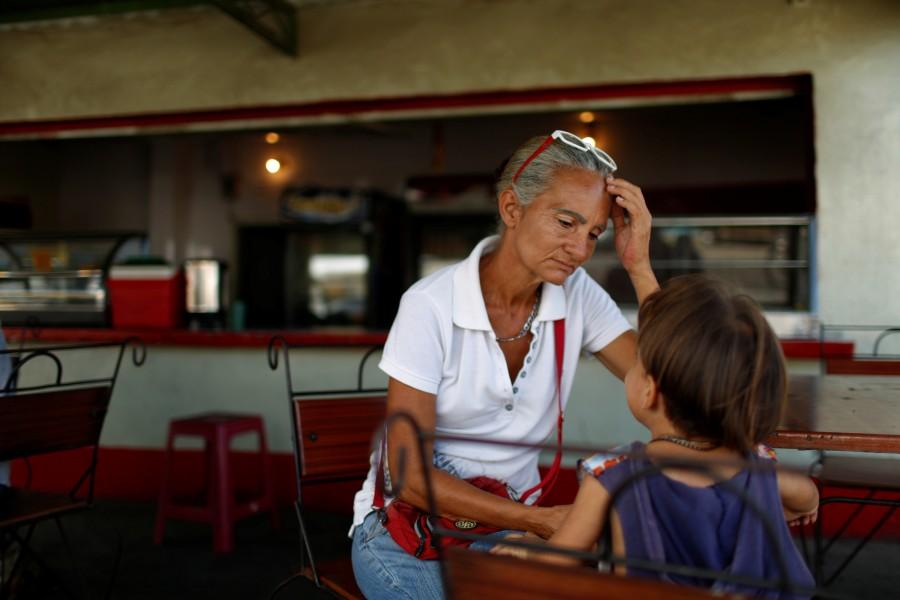 Zulay Pulgar (C), 43, rest in a coffee shop with her son Emmanuel, 4, after standing in line to buy cement in a hardware store in Punto Fijo, Venezuela. The family lives on Pulgar's father's pension, worth $6 a month at the black market rate, in a country where prices for many basic goods are surpassing those in the United States. Crisis forces,Venezuelan,Venezuelan parents,United States,Zulay Pulgar,Juan Pulgar