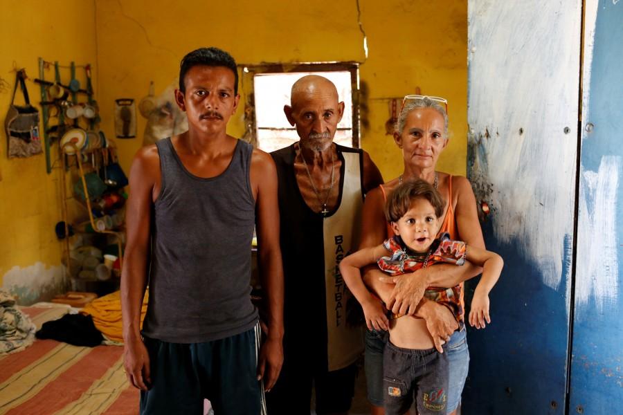 Zulay Pulgar (R), 43, holds her son Emmanuel, 4, next to her husband Maikel Cuauro (L), 30, and her father Juan Pulgar, 73, while they pose for a portrait in their house in Punto Fijo, Venezuela. Struggling to feed herself and her seven children, Venezuelan mother Zulay Pulgar asked a neighbor in October to take over care of her six-year-old daughter, a victim of a pummeling economic crisis. Crisis forces,Venezuelan,Venezuelan parents,United States,Zulay Pulgar,Juan Pulgar