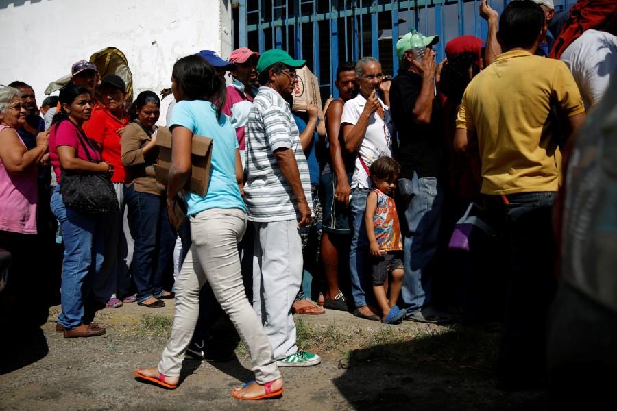 Zulay Pulgar (C), 43, stands in line outside a hardware store, next to her son Emmanuel, to buy cement and resell it in Punto Fijo, Venezuela. Crisis forces,Venezuelan,Venezuelan parents,United States,Zulay Pulgar,Juan Pulgar