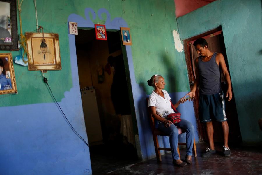 Zulay Pulgar (C), 43, gives Venezuelan bolivar notes to her husband Maikel Cuauro, 30, in their house in Punto Fijo, Venezuela. Crisis forces,Venezuelan,Venezuelan parents,United States,Zulay Pulgar,Juan Pulgar
