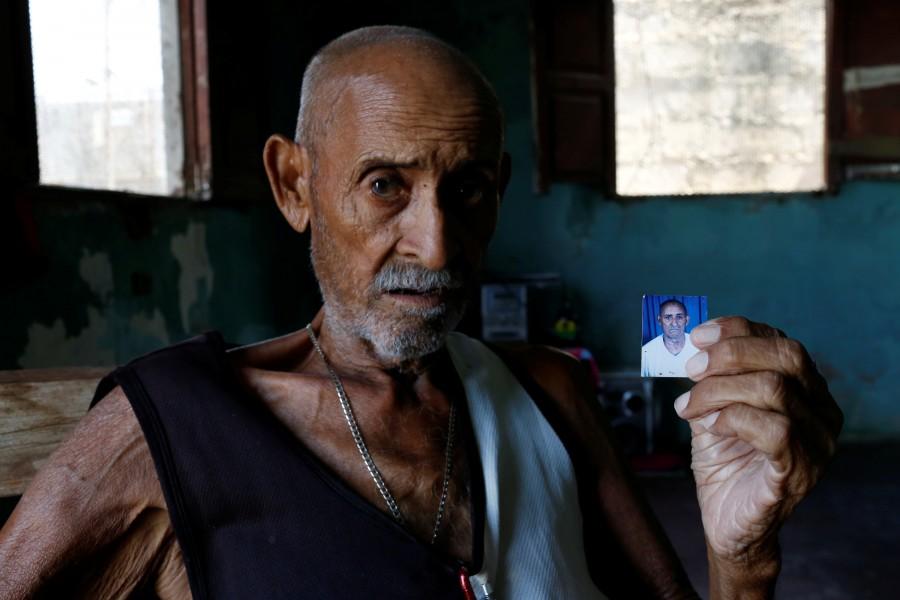 Juan Pulgar, 73, holds a picture of himself taken about a year ago, as he poses for a portrait in his house in Punto Fijo, Venezuela. Crisis forces,Venezuelan,Venezuelan parents,United States,Zulay Pulgar,Juan Pulgar
