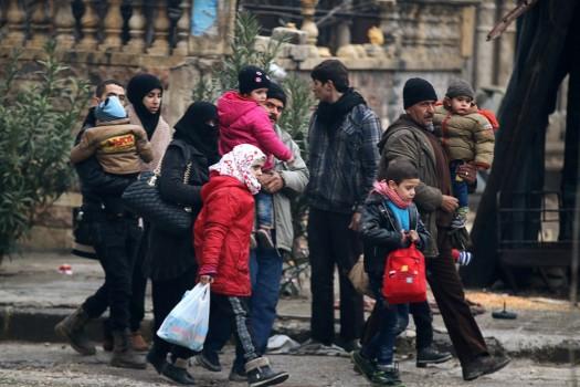 People carry their belongings as they flee deeper into the remaining rebel-held areas of Aleppo, Syria.