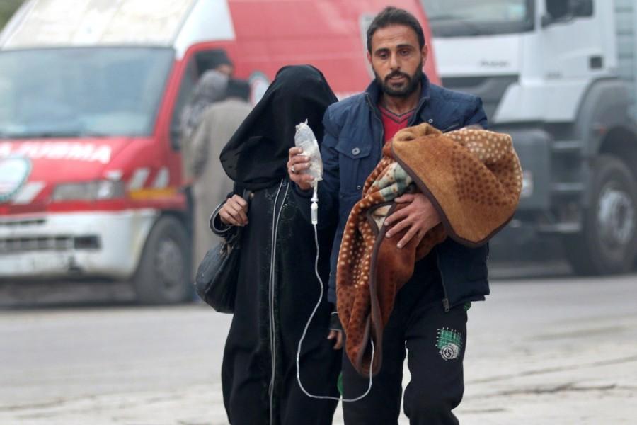 A man carries a child with an IV drip as he flees deeper into the remaining rebel-held areas of Aleppo, Syria. Aleppo,Syrian city,Russia,rebel-held Aleppo,Syria,Syria crisis,Battles for Aleppo in Syria,Battles for Aleppo