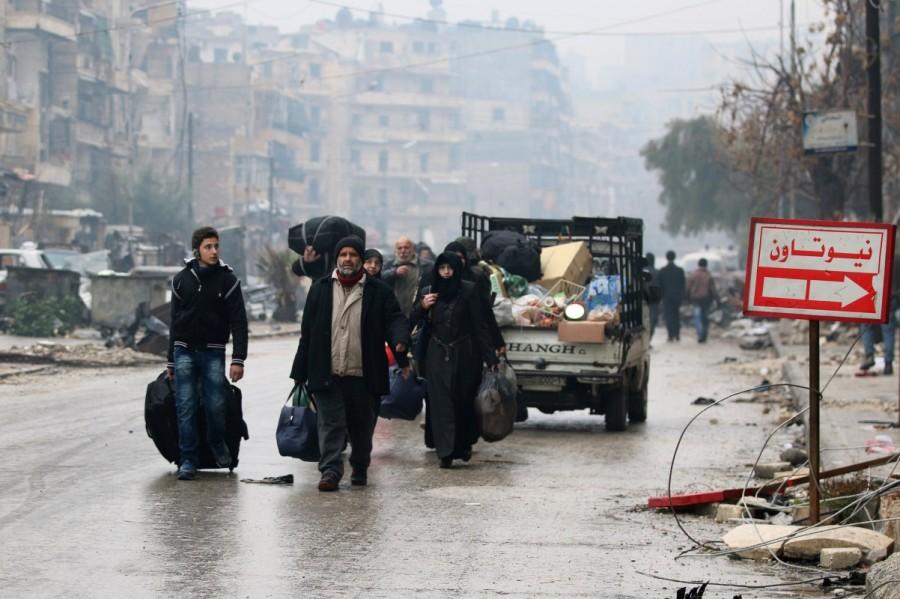 People carry their belongings as they flee deeper into the remaining rebel-held areas of Aleppo, Syria. Aleppo,Syrian city,Russia,rebel-held Aleppo,Syria,Syria crisis,Battles for Aleppo in Syria,Battles for Aleppo