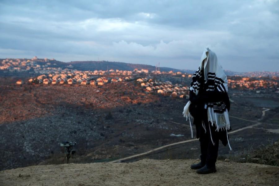 A Jewish man covered in a prayer shawl, prays in the Jewish settler outpost of Amona in the West Bank. Israeli,life in Israeli,Life in Israeli settlements,U.N. Security Council