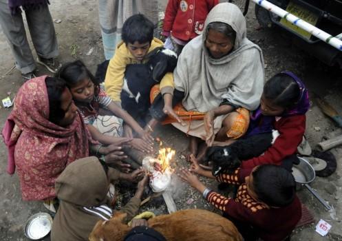 People warm themselves around a bonfire during a cold winter day in Patna on Dec 27, 2016.
