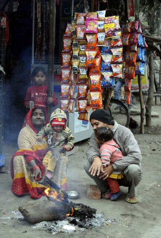People warm themselves around a bonfire during a cold winter day in Patna on Dec 27, 2016. Patna shivers,temperature dips in Patna,cold winter in Patna,Patna shivers as temperature dips,minimum temperatures dipping