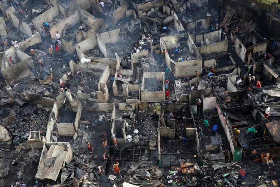 Residents sift through the ruins of their houses after a fire razed a squatter colony, in Quezon city, Metro Manila in the Philippines December 28, 2016. The fire left over a thousand families homeless. Philippine slum,Fire at Philippine slum,Manila shantytown