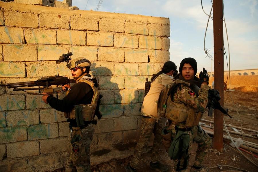 Iraqi security forces take cover during clashes with Islamic State militants, north of Mosul. More than 5,000 soldiers and federal police troops, redeployed from Mosul's southern outskirts, entered half a dozen southeastern districts, while counter-terrorism forces advanced in al-Quds and Karama districts after reinforcements arrived. Second phase of Mosul,Mosul,Mosul offensive begins,Islamic State militants,Iraqi security forces,Islamic State,Battle of Mosul