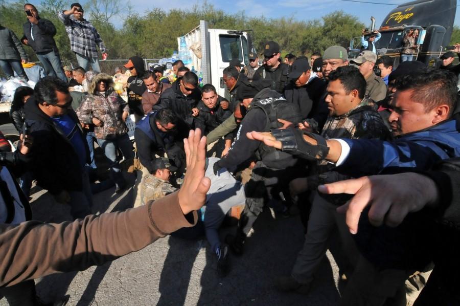 Policemen (C) detain demonstrators during a protest against the rising prices of gasoline enforced by the Mexican government, in Monclova, in Coahuila state, Mexico, January 5, 2017. Mexicans,Mexico gas price hike,gas price hike,gasoline prices,Latin America,blockaded roads