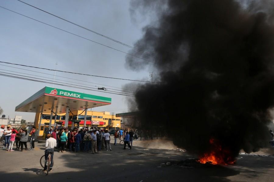 Protesters block the entrance to a Pemex gas station as they burn tires during a protest in San Miguel Totolcingo, Mexico. Mexican President Enrique Pena Nieto said that the price spike that took effect on Jan. 1 was a "responsible" measure that the government took in line with international oil prices. The hike is part of a gradual, year-long price liberalization the Pena Nieto administration has promised to implement this year. Mexicans,Mexico gas price hike,gas price hike,gasoline prices,Latin America,blockaded roads