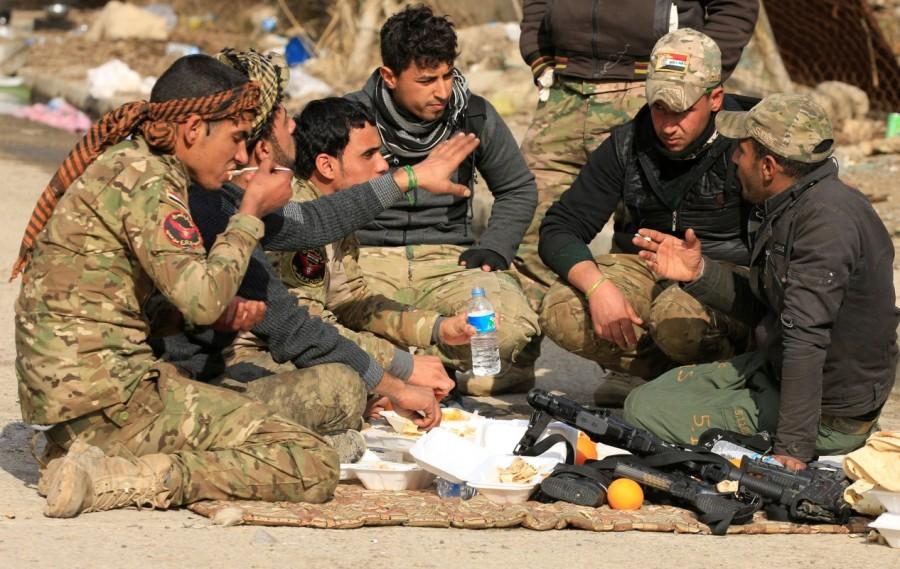 Iraqi rapid response forces eat food during clashes with Islamic State militants, in Sumer neighborhood of Mosul, Iraq, January 13, 2017. Mosul,War in Mosul,Iraqi forces,State block,eastern Mosul