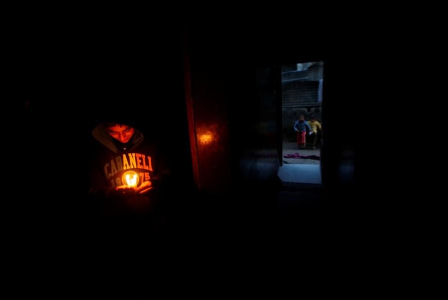 A Palestinian boy holds candles to light his family's house during a power cut in Beit Lahiya in the northern Gaza Strip. Lights out in Gaza,Gaza Lights out,darkened streets,Beit Lahiya,northern Gaza Strip