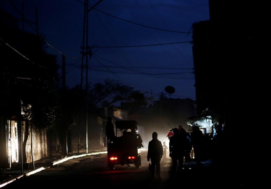 Palestinians walk on a street during a power cut in Beit Lahiya in the northern Gaza Strip. Lights out in Gaza,Gaza Lights out,darkened streets,Beit Lahiya,northern Gaza Strip
