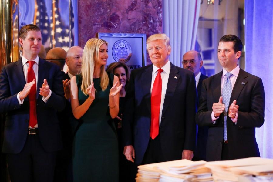 President-elect Donald Trump (C) smiles as he is applauded by his son Eric Trump (L) daughter Ivanka and son Donald Trump Jr. (R) ahead of a press conference in Trump Tower, Manhattan. Donald Trump,Donald Trump first news conference,president Donald Trump,President-elect Donald Trump,Manhattan,Trump Tower