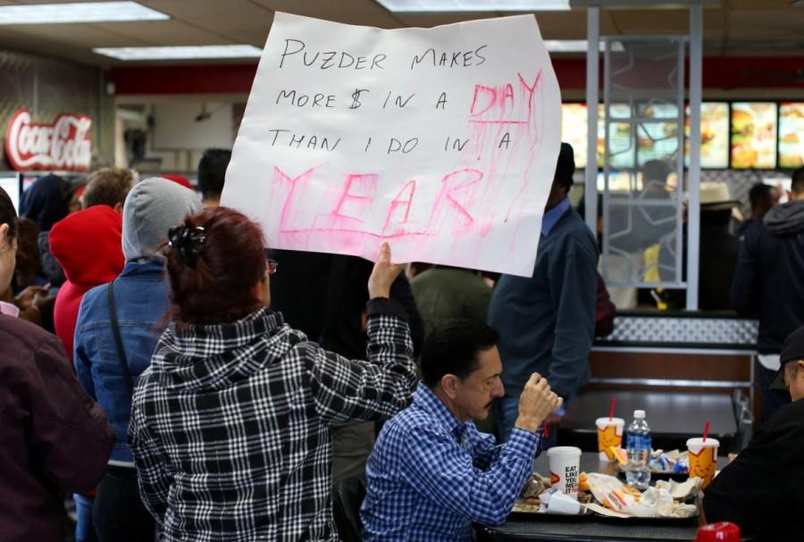 Customers try and eat their lunch as protesters take part in nationwide protests to denounce President-elect Donald Trump's nomination of Andy Puzder as Secretary of Labor inside a Carl's Jr. restaurant in Los Angeles, California. Donald Trump,Fight for $15,labor secretary nominee,Donald Trump labor secretary nominee,President-elect Donald Trump,against Andrew Puzder,Andrew Puzder
