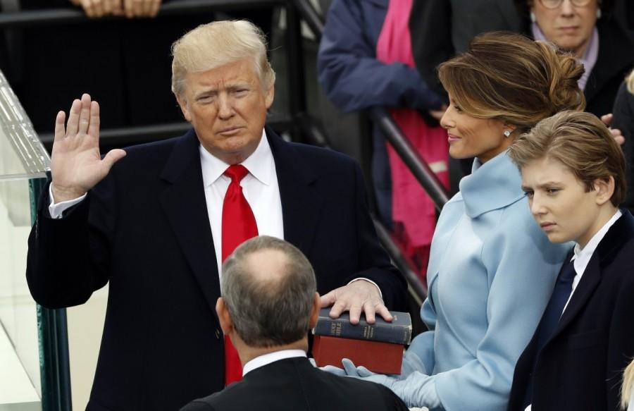 Donald Trump takes the oath of office with his wife Melania and son Barron at his side. Donald Trump,Presidential inauguration,Donald Trump inauguration,45th president of America,Donald Trump as 45th president of America,Donald Trump inauguration pics,Donald Trump inauguration images,Donald Trump inauguration photos,Donald Trump inauguration
