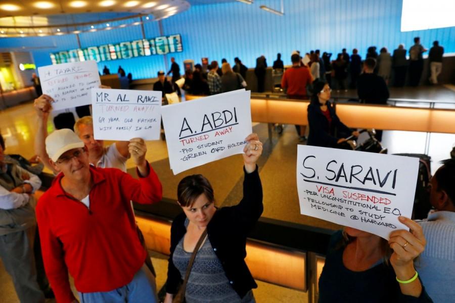 People hold signs with the names of people detained and denied entry in protest of Donald Trump's travel ban at Los Angeles International Airport (LAX) in Los Angeles, California. Trump,Donald Trump,Muslim immigrants,Muslim immigrants ban,ban Muslim immigrants,United States,President Trump,U.S.-bound flights