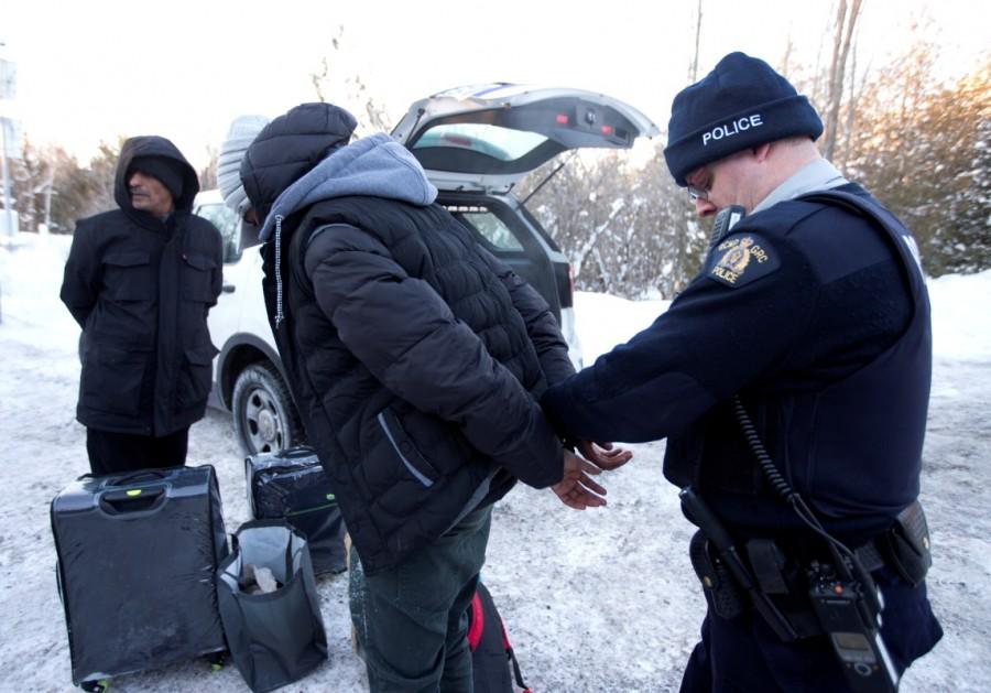 A family from Yemen is taken into custody by Royal Canadian Mounted Police (RCMP) officers after walking across the U.S.-Canada border into Hemmingford. Hemmingford,U.S.-Canada border,Canada from the U.S,Quebec,cross by foot,U.S. border,Canada border