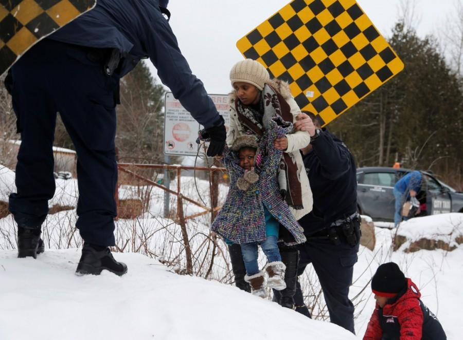 A woman who told police that she and her family were from Sudan is taken into custody by Royal Canadian Mounted Police (RCMP) officers after arriving by taxi and walking across the U.S.-Canada border into Hemmingford, Quebec, Canada February 12, 2017. In Quebec, 1,280 refugee claimants irregularly entered between April 2016 and January 2017, triple the previous year's total. Hemmingford,U.S.-Canada border,Canada from the U.S,Quebec,cross by foot,U.S. border,Canada border