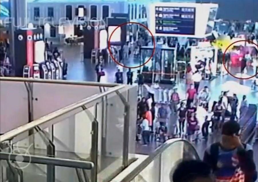 A still image from a CCTV footage appears to show (circled in red) a man purported to be Kim Jong Nam being accosted by a woman in a white shirt at Kuala Lumpur International Airport in Malaysia on February 13, 2017. Malaysian authorities,Kim Jong Un,Kim Jong Un death,death of Kim Jong Un,Kim Jong Un murder,Kim Jong Un brother murder