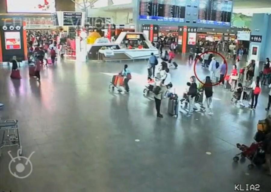 A still image from a CCTV footage appears to show (circled in red) a man purported to be Kim Jong Nam being accosted by a woman in a white shirt at Kuala Lumpur International Airport in Malaysia on February 13, 2017. Malaysian authorities,Kim Jong Un,Kim Jong Un death,death of Kim Jong Un,Kim Jong Un murder,Kim Jong Un brother murder