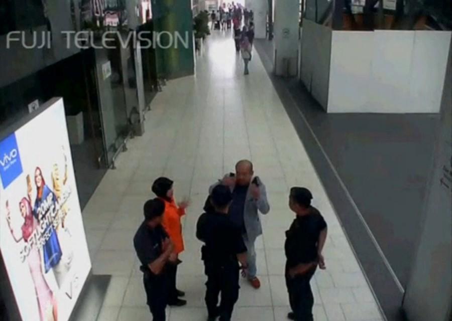 A still image from a CCTV footage appears to show a man purported to be Kim Jong Nam talking to security personnel, after being accosted by a woman in a white shirt, at Kuala Lumpur International Airport in Malaysia on February 13, 2017. Malaysian authorities,Kim Jong Un,Kim Jong Un death,death of Kim Jong Un,Kim Jong Un murder,Kim Jong Un brother murder
