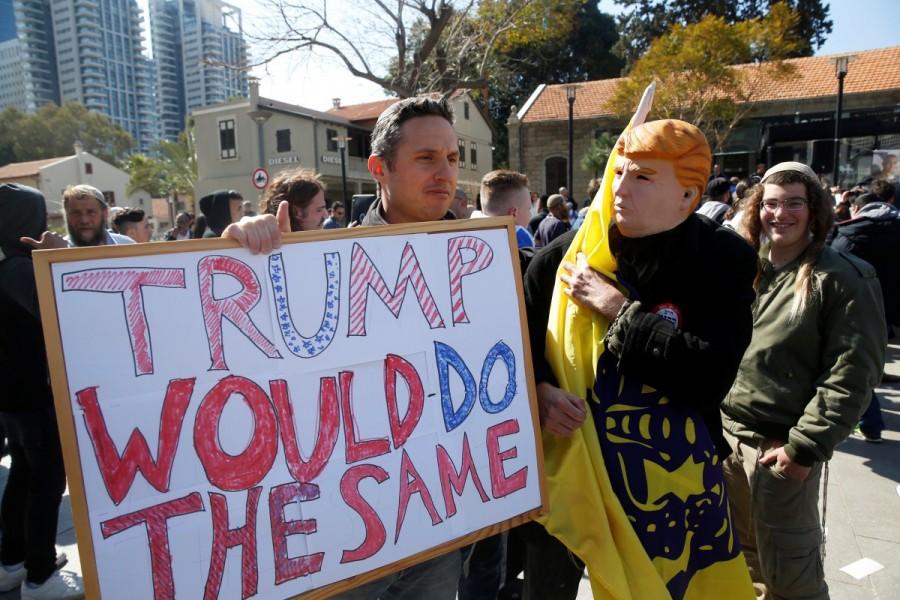 A protester holds a sign as a man dressed up as U.S. President Donald Trump stands next to him during a demonstration in support of Israeli soldier Elor Azaria, outside a military court in Tel Aviv, Israel February 21, 2017. Israeli soldier,Palestinian assailant,killing Palestinian,Palestinian,Israeli soldier Elor Azaria,Elor Azaria