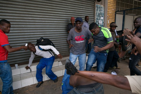 A vigilante mob attacks a Nigerian man outside a church in Pretoria, South Africa February 18, 2017. Somali immigrants,South African,Nigerian migrant,Pretoria,South African mobs,immigrants attack