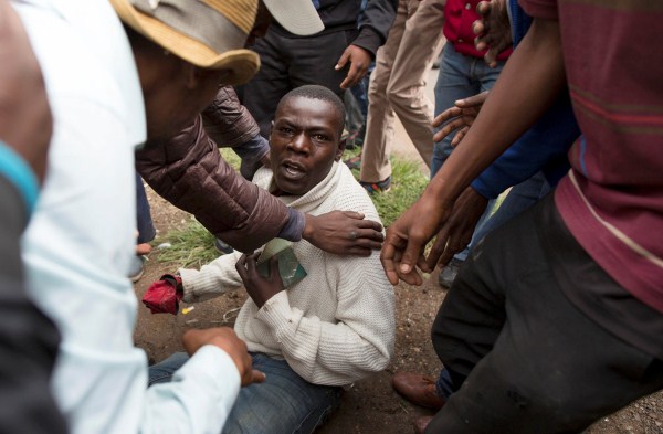 A man holds his South African identity document after being attacked by a mob in Pretoria, South Africa, February 24, 2017. Police fired tear gas, water cannon and rubber bullets to disperse rival marches by hundreds of protesters in Pretoria on Friday, after mobs looted stores this week believed to belong to immigrants. Somali immigrants,South African,Nigerian migrant,Pretoria,South African mobs,immigrants attack