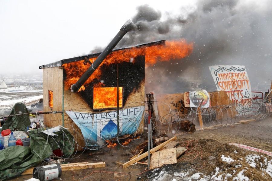 A structure burns after being set alight by protesters preparing to evacuate the main opposition camp against the Dakota Access oil pipeline near Cannon Ball, North Dakota, U.S., February 22, 2017. Standing Rock,Last stand at Standing Rock,Dakota Access pipeline,Dakota Access