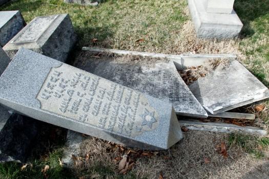 A headstone, pushed off its base by vandals, lays on the ground near a smashed tomb in the Mount Carmel Cemetery, a Jewish cemetery, in Philadelphia, Pennsylvania. About 100 headstones were knocked over, police said, in an incident that apparently took place after dark on February 25.
