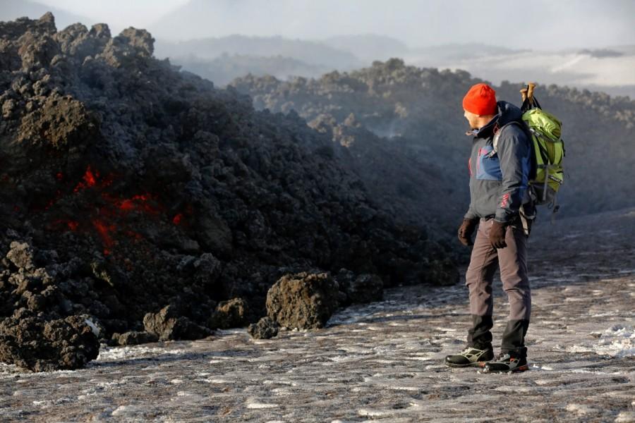 Volcano guide stands in front of lava pouring from Italy's Mount Etna, Europe's tallest and most active volcano, during an eruption on the southern island of Sicily, Italy February 28, 2017. Mount Etna erupts,Mount Etna,Volcano's Eruptions,Volcano Eruptions,Volcano,lava,Italy