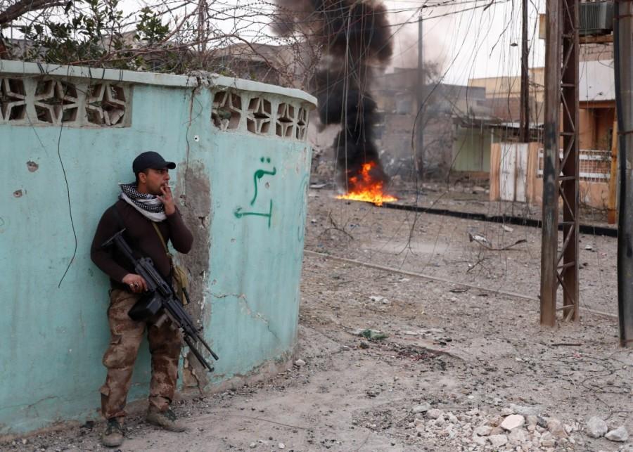 An Iraqi special forces soldier smokes as he takes a break during a battle between Iraqi special forces soldiers and Islamic State militants in Mosul, Iraq March 1, 2017. Tigris river,Brutal street,Mosul,U.S,Islamic State,damaged bridge,Iraqi special forces,Iraqi forces,Iraqi special forces in Mosul