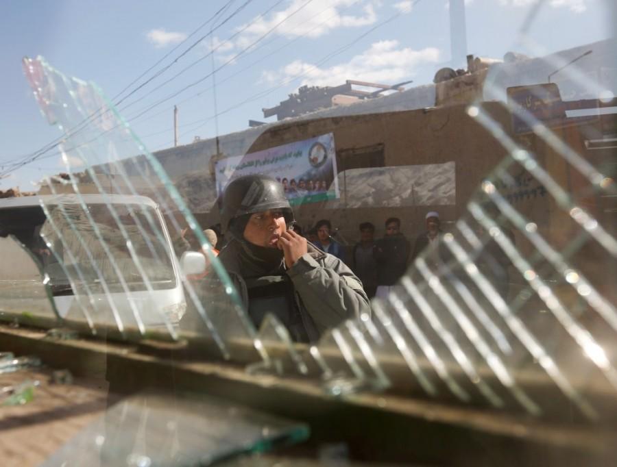 An Afghan policeman looks outside through a broken window at the site of a blast and gunfire between Taliban and Afghan forces in PD 6 as policemen keep watch in Kabul. Taliban,Taliban car bomb attack,bomb attack in Kabul,Taliban bomb attack,Afghan Taliban militants,Afghan militants,Taliban militants
